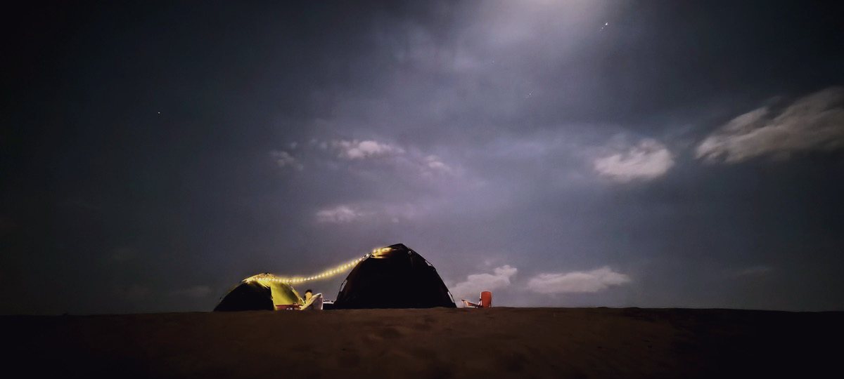 Campement discret dans le désert omanais sous le ciel nocturne